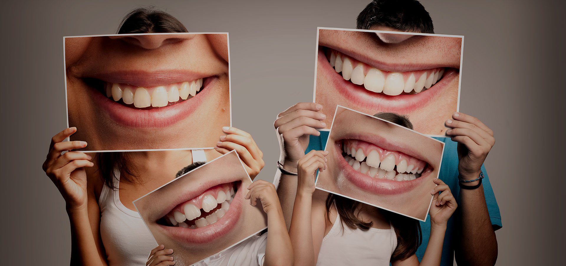People holding up photos of smiles - benefits of a dentist